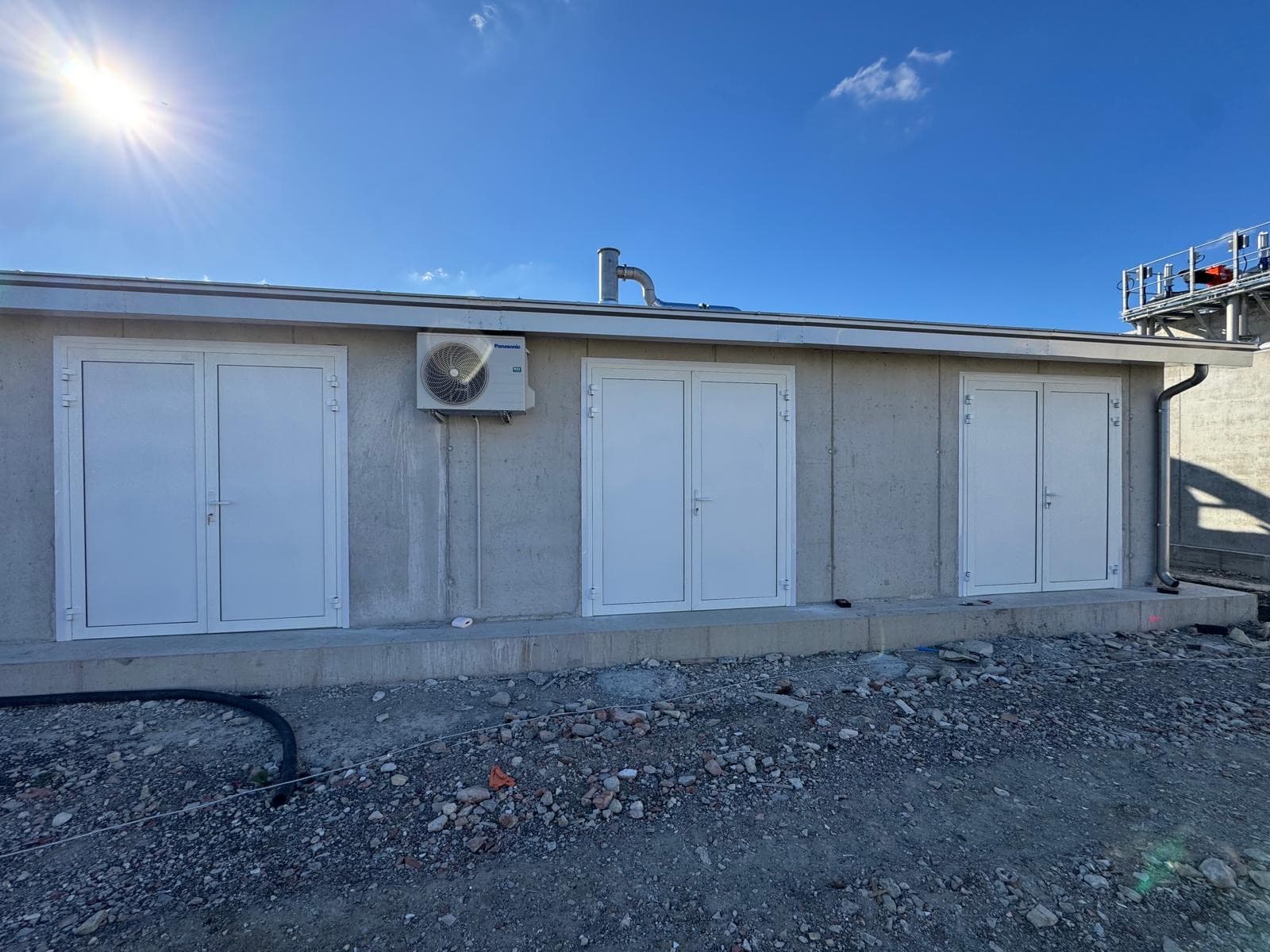 Posa porte tecniche in alluminio bianco su edificio industriale