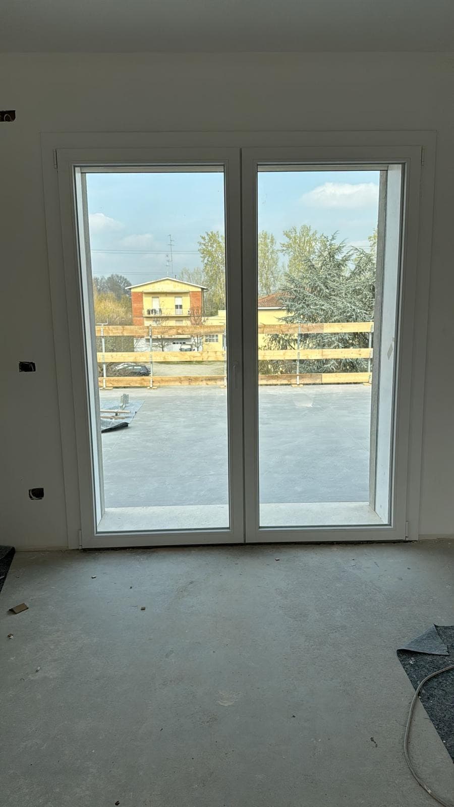 Portafinestra a due battenti in PVC bianco installata in nuovo appartamento